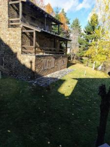 an old brick building with a grassy yard at Precioso Apartamento en la Cerdanya in La Molina