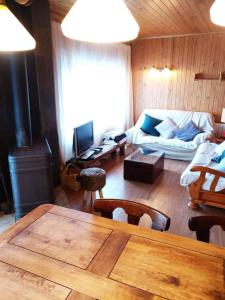 sala de estar con mesa, sofá y chimenea en Precioso apartamento en la Cerdanya (6 personas)., en La Molina