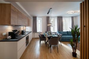 uma cozinha e sala de estar com uma mesa e um sofá em Altstadt-App. Domblick! em Salzburgo