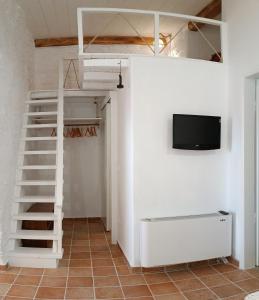 Habitación con litera y TV en la pared. en Est 1852 - Katoi Art, en Ándros