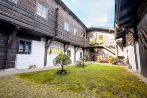 a courtyard of a house with a tree in the yard at Penzion Sněžná Volary in Volary