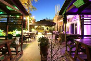 an outdoor patio with tables and chairs and an umbrella at Turkuaz Boutique Hotel in Buyukcekmece