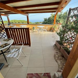 a patio with tables and chairs on a roof at Scapriccio Relax in Serrara Fontana