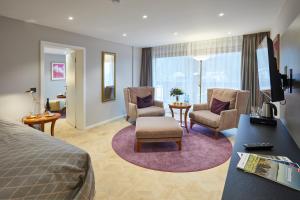 a hotel room with a bed and chairs and a living room at Erfurths Bergfried Ferien & Wellnesshotel in Hinterzarten