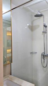a bathroom with a shower with a glass door at The cozy & luxury room in Podomoro City Deli Medan in Medan