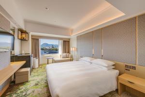 a hotel room with a large bed and a television at Hotel Nikko Kumamoto in Kumamoto