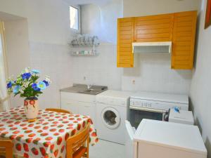 una cucina con tavolo e lavatrice di Inviting Holiday Home with Terrace Garden Furniture BBQ a Rio
