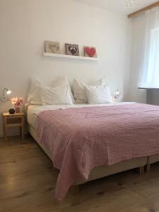 una camera con un letto e una coperta rosa di Feriendomizil Suldis a Batschuns