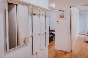 una stanza con armadi bianchi e uno specchio sul muro di Z'Argette Apartment - Free Parking @ Zagrebacka C. a Zagabria