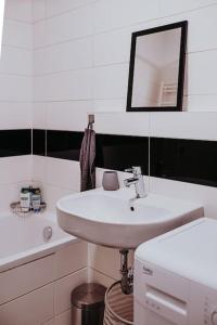 ein weißes Badezimmer mit einem Waschbecken und einem Spiegel in der Unterkunft Z'Argette Apartment - Free Parking @ Zagrebacka C. in Zagreb
