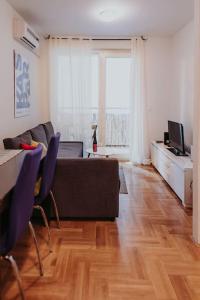 een woonkamer met een bank en een tafel bij Z'Argette Apartment - Free Parking @ Zagrebacka C. in Zagreb