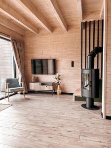 a living room with a fireplace and a tv at Amalkowelove stodoła Kaszuby in Podiazy