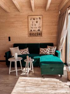 a living room with a green couch and two tables at Amalkowelove stodoła Kaszuby in Podiazy