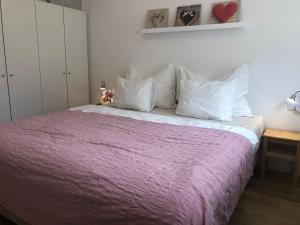 1 dormitorio con 1 cama con manta morada y almohadas blancas en Feriendomizil Suldis, en Batschuns