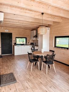 a kitchen and dining room with a table and chairs at Amalkowelove stodoła Kaszuby in Podiazy