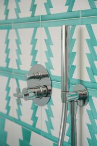 a glass shower in a bathroom with blue and white tiles at Villa Pasquale Capri in Capri