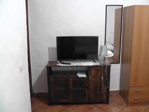 een televisie op een houten standaard in een kamer bij Sardinia Experience in Villamassargia