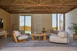 a living room with a couch and two chairs and a table at ERTH Abu Dhabi Hotel in Abu Dhabi