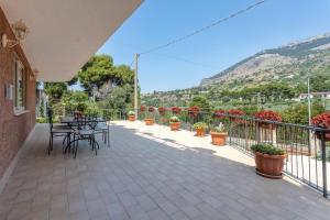 uma varanda com mesa, cadeiras e plantas em Villa Salvatore em Torretta