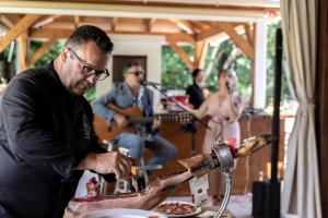 a man preparing food on a table with people playing instruments at Hotel Tossal d'Altea in Altea