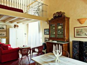 a living room with a table and a red couch at Charming Elegant castle flat with large garden in Rocca Grimalda