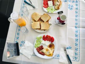 uma mesa com dois pratos de comida e bebidas para o pequeno-almoço em HOTEL SARDA em Vau i Dejës