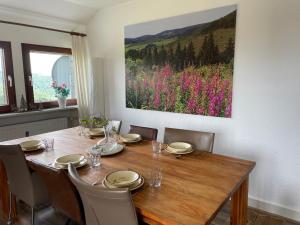 einen Esstisch mit Stühlen und ein Gemälde an der Wand in der Unterkunft Apartment Haus Aktiv Top in Winterberg
