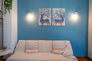 a blue room with a couch with two paintings on the wall at Piraeus 2 bedrooms 4 persons apartmnet by MPS in Piraeus