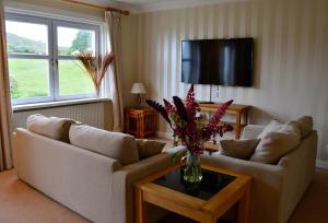 a living room with a couch and a vase of flowers on a table at Portling View in Dalbeattie