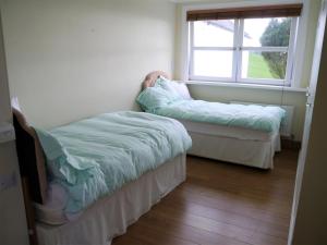a room with two beds and a window at Portling View in Dalbeattie