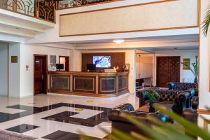 a lobby with leather chairs and a flat screen tv at Hotel Del Mar & Conference Center in Mamaia