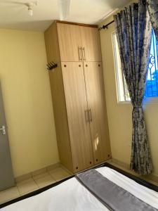 Zimmer mit einem Schrank und einem Fenster in der Unterkunft Kwetu House in Mombasa