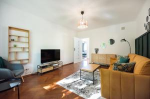 a living room with a couch and a tv at Ratusz Arsenał Modern Apartment in Warsaw