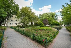 a garden with pink flowers in a park at Ratusz Arsenał Modern Apartment in Warsaw