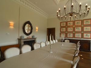 a dining room with a table and chairs and a chandelier at Luxurious castle in Marchin with infrared sauna in Tharoul