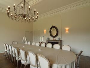 a dining room with a long table and a chandelier at Luxurious castle in Marchin with infrared sauna in Tharoul