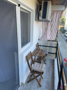 une chaise en bois assise sur le balcon d'une petite maison dans l'établissement LaVoiLaNoi, à Mangalia