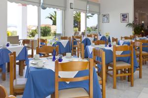 a dining room with blue tables and chairs at Palatino Hotel in Lixouri