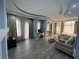 a large living room with a couch and a television at Hotel Nica in Batumi