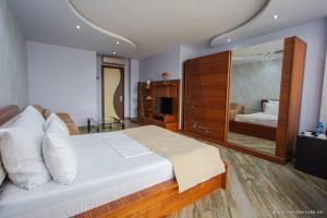 a bedroom with a large bed with a large mirror at Hotel Nica in Batumi