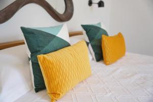 drei grüne und gelbe Kissen auf einem Bett in der Unterkunft Villa Pasquale Capri in Capri