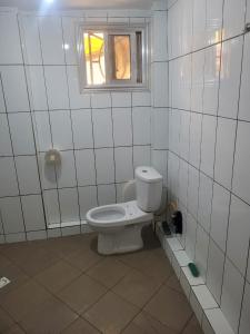 La salle de bains est pourvue de toilettes et d'une fenêtre. dans l'établissement Résidence Diakhaby, à Conakry