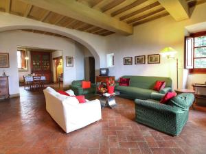 un soggiorno con divani verdi e cuscini rossi di Apartment in a farmhouse with swimming pool a Rufina