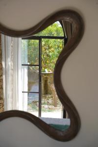 einen Spiegel mit Blick auf ein Fenster mit Aussicht in der Unterkunft Villa Pasquale Capri in Capri