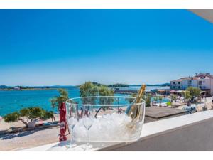 a wine glass sitting on a ledge next to the beach at Modern apartment right on the Janice beach in Pakostane centre 50 m away in Pakoštane