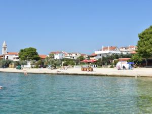 a body of water with a beach and buildings at Modern apartment right on the Janice beach in Pakostane centre 50 m away in Pakoštane