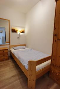 1 dormitorio con cama de madera y espejo en Vier Jahreszeiten 1-37, en Großenbrode