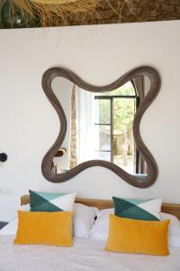 a mirror above a bed with orange pillows at Villa Pasquale Capri in Capri