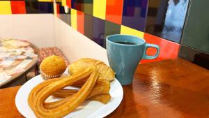 un plato de comida con un pretzel y una taza de café en Way Hostel Madrid, en Madrid