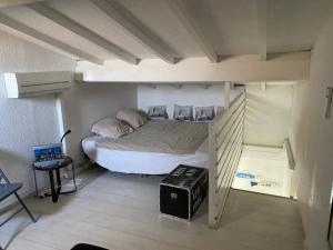 a bedroom with a bunk bed in a room at Charmante maisonnette proche plage in Cap d'Agde